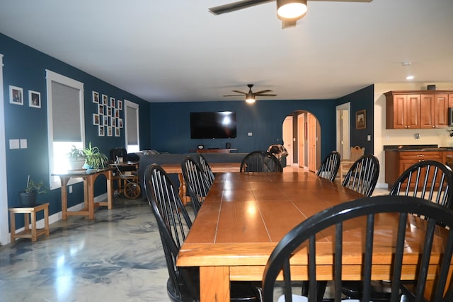 18 Castle Rd, Harmony, ME 04942 - dining room featuring a ceiling fan, baseboards, arched walkways, and finished concrete floors