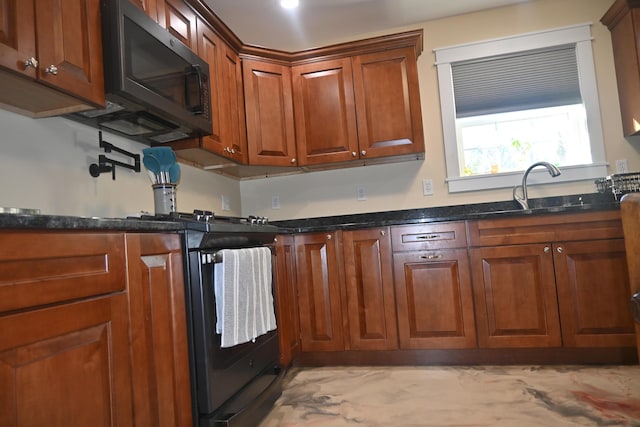 18 Castle Rd, Harmony, ME 04942 - kitchen featuring dark stone counters, brown cabinetry, a sink, and stainless steel gas stove