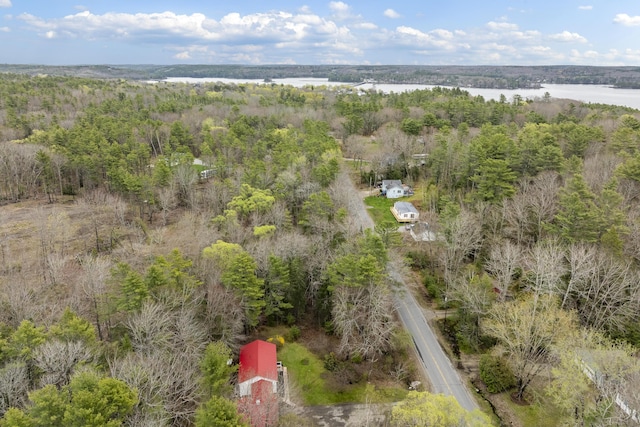 drone / aerial view of a heavily wooded area and a nearby body of water