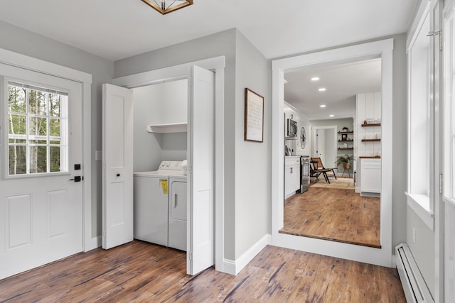 laundry area featuring a baseboard heating unit, washer and clothes dryer, wood finished floors, baseboards, and recessed lighting
