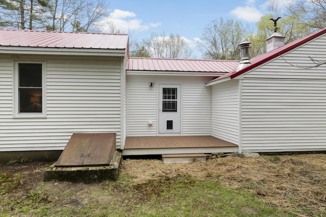 back of property featuring a deck and metal roof