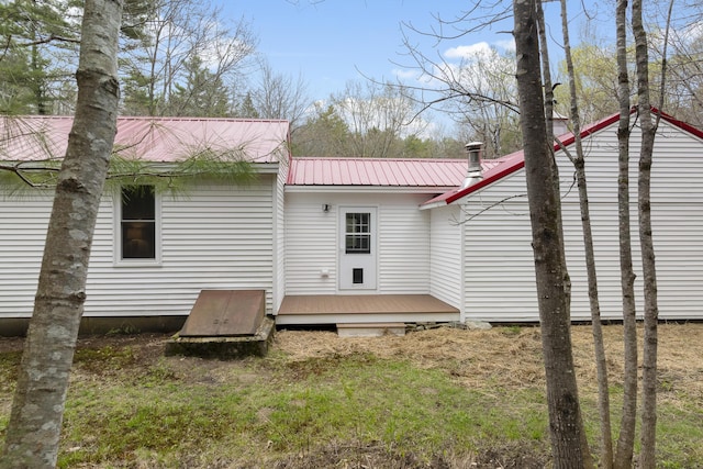 rear view of house featuring metal roof and a wooden deck