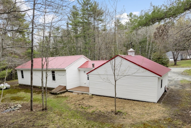 rear view of house with metal roof and a chimney