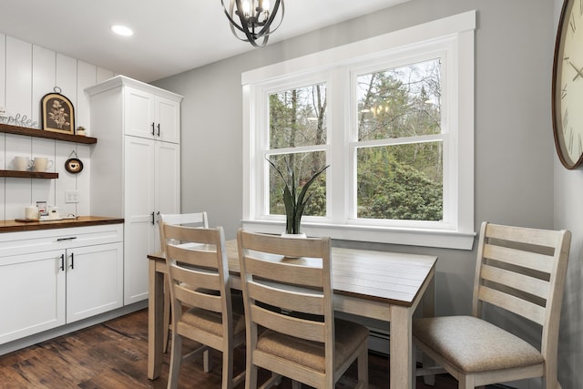 dining area with dark wood-style flooring, a chandelier, and recessed lighting