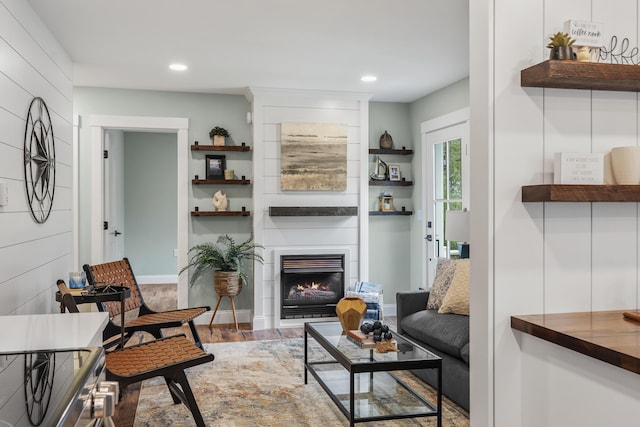 living room featuring a fireplace, recessed lighting, and wood finished floors