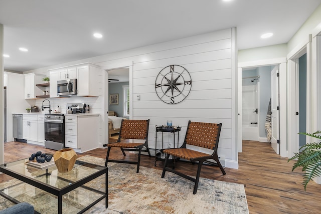 living area featuring wood finished floors, recessed lighting, and stairs