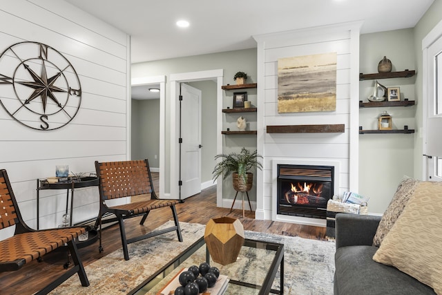 living room featuring wood finished floors, a fireplace, recessed lighting, and baseboards