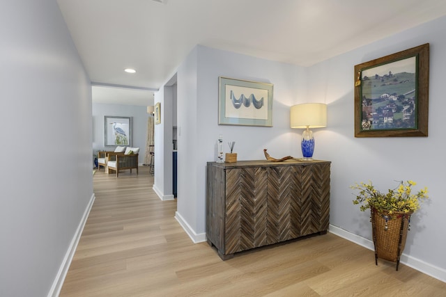hall featuring light wood-style floors, recessed lighting, and baseboards