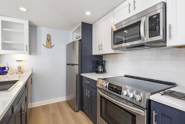 kitchen with stainless steel appliances, white cabinetry, light wood finished floors, and recessed lighting