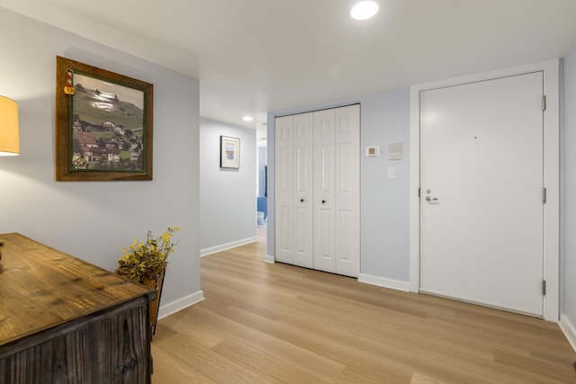 corridor featuring light wood-style flooring, recessed lighting, and baseboards
