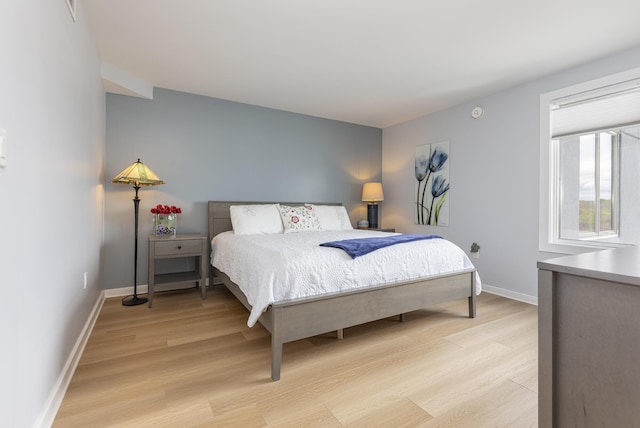 bedroom with light wood-style flooring and baseboards