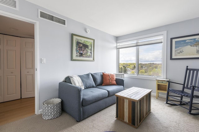 living area with light carpet and baseboards