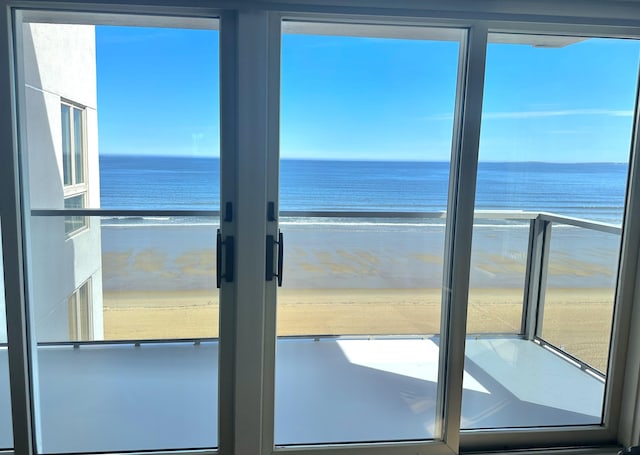 doorway featuring view of water and beach