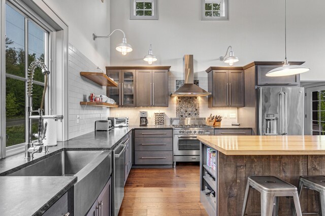 28 Fisher Rd, Newry, ME 04261 - kitchen featuring high quality appliances, wall chimney range hood, a sink, decorative backsplash, and healthy amount of natural light