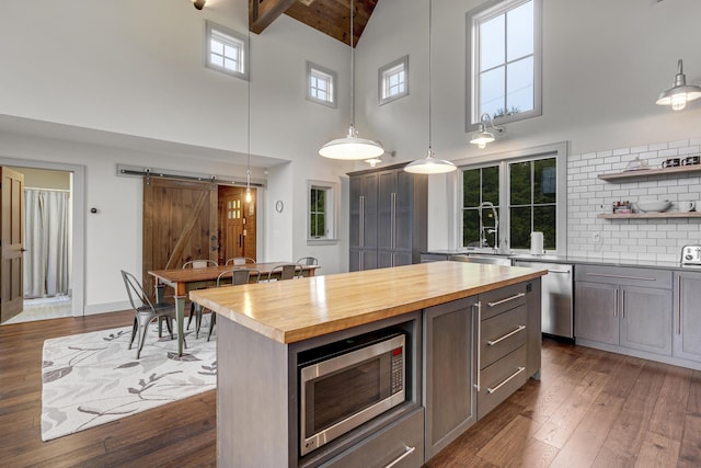 28 Fisher Rd, Newry, ME 04261 - kitchen with a barn door, appliances with stainless steel finishes, high vaulted ceiling, butcher block countertops, and a sink