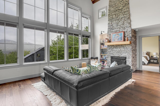 28 Fisher Rd, Newry, ME 04261 - living area with a towering ceiling, hardwood / wood-style floors, a stone fireplace, and baseboards