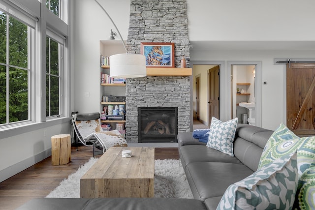 28 Fisher Rd, Newry, ME 04261 - living room featuring a barn door, a stone fireplace, and wood finished floors