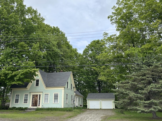 111 Town Farm Rd, Farmington, ME 04938 - view of front facade featuring an outdoor structure, a detached garage, roof with shingles, and view of wooded area