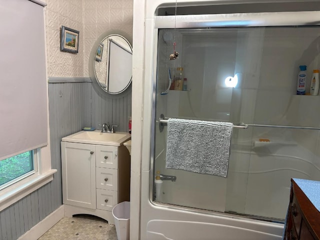 111 Town Farm Rd, Farmington, ME 04938 - full bath featuring vanity, bath / shower combo with glass door, wallpapered walls, and a wainscoted wall