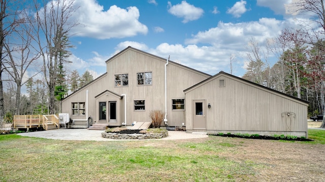 rear view of property featuring a lawn, a patio area, and a deck