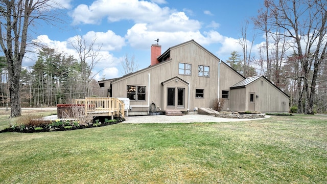 rear view of property with a lawn, a chimney, entry steps, and a deck