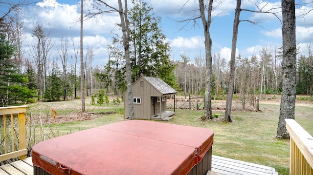 deck with a lawn, a hot tub, a shed, and an outbuilding