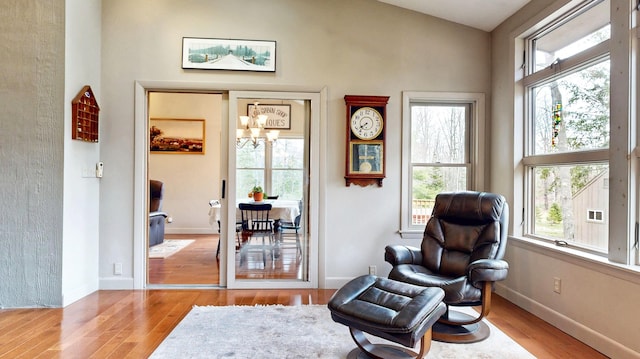sitting room with an inviting chandelier, wood finished floors, and a wealth of natural light