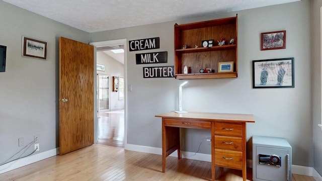 office space with baseboards and wood finished floors