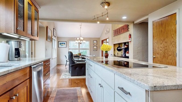 kitchen featuring stainless steel dishwasher, vaulted ceiling, black electric cooktop, a chandelier, and light wood-style flooring