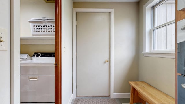 washroom with washer and dryer, laundry area, and baseboards