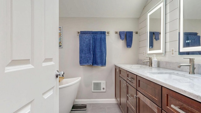 full bath featuring a sink, baseboards, a soaking tub, and visible vents