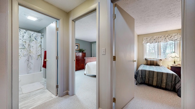 hall with carpet, a textured ceiling, and visible vents