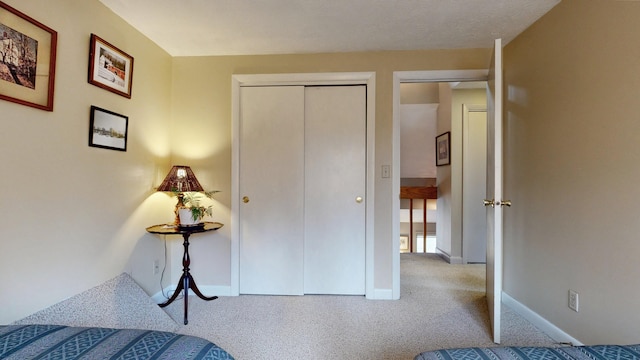 bedroom with carpet floors, baseboards, and a closet