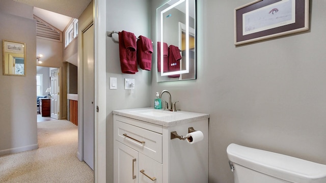 bathroom with vanity, vaulted ceiling, and toilet