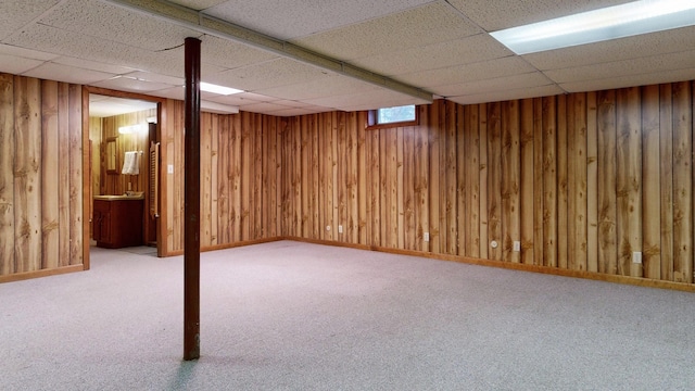below grade area with carpet and a paneled ceiling