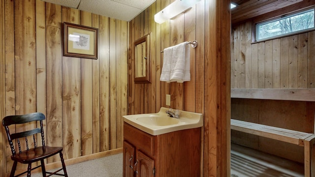 bathroom featuring vanity and wood walls