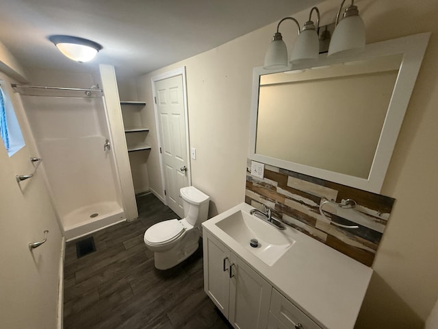 full bath featuring vanity, toilet, a shower stall, wood finished floors, and visible vents