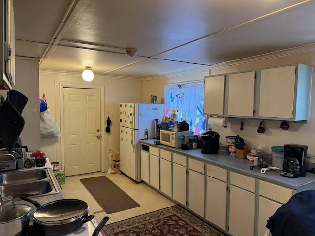 kitchen with a sink, white cabinets, and white appliances
