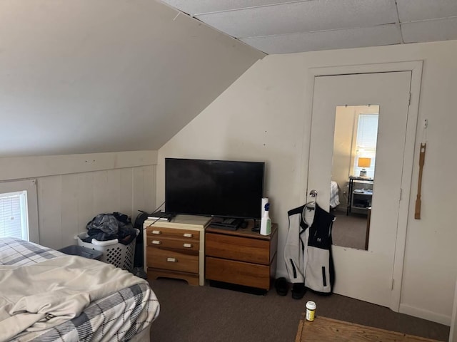 bedroom with dark carpet and lofted ceiling