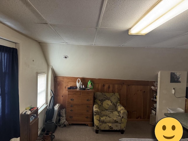 bedroom featuring carpet, wooden walls, and a paneled ceiling