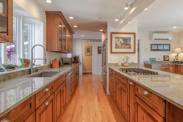 20 Giant Slide Rd, Mount Desert, ME 04660 - kitchen with a sink, a wall mounted air conditioner, stainless steel appliances, light wood-style floors, and light stone counters