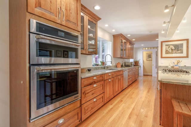 20 Giant Slide Rd, Mount Desert, ME 04660 - kitchen with stainless steel appliances, brown cabinets, light stone counters, a sink, and glass insert cabinets