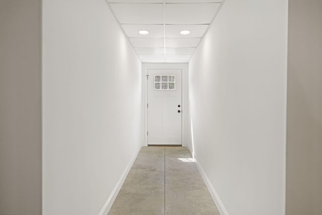 hall featuring baseboards, recessed lighting, and concrete floors