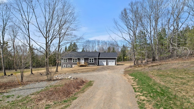 single story home with an attached garage and dirt driveway