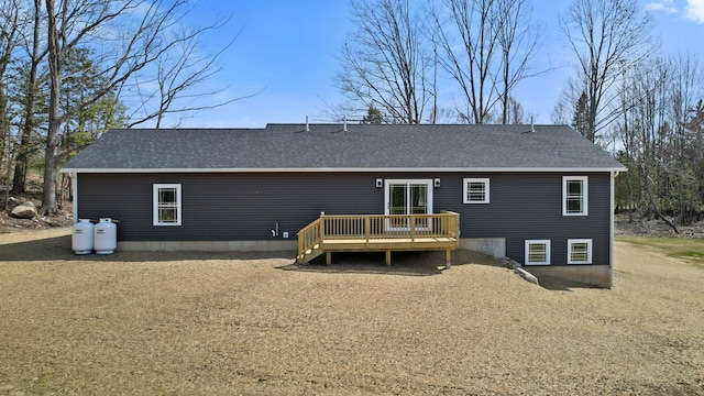 back of house with roof with shingles and a deck