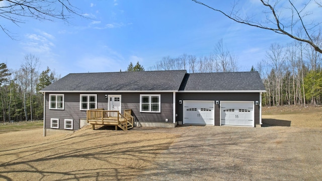ranch-style home featuring a garage, roof with shingles, and dirt driveway
