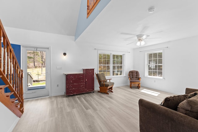 living area with light wood-style floors, ceiling fan, plenty of natural light, and stairs