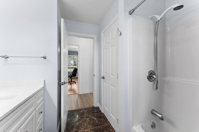 bathroom featuring vanity, baseboards, shower / tub combination, and marble finish floor