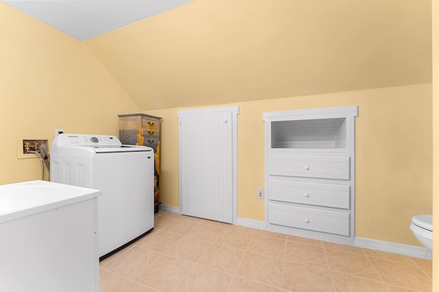 clothes washing area with washer / clothes dryer, laundry area, and baseboards