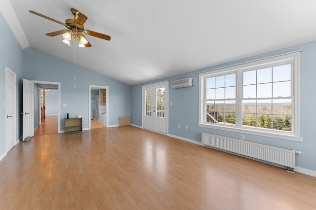 unfurnished living room with ceiling fan, vaulted ceiling, radiator heating unit, and light wood-style floors